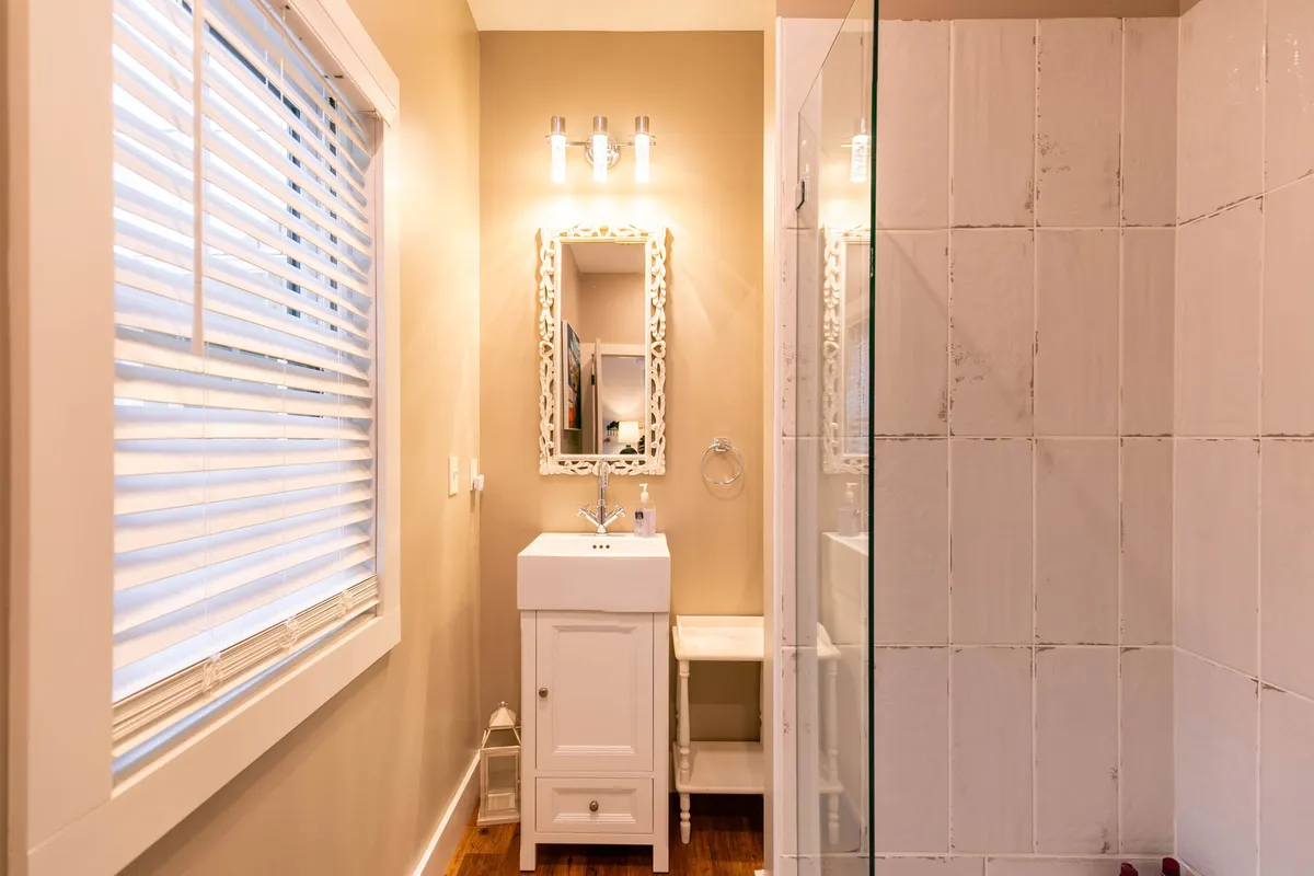 A spa-inspired bathroom is captured with a mirrored vanity, a clean glass shower enclosure, and abundant natural light. The calm atmosphere invites self-care and relaxation, underscoring the luxury of the home's bathrooms.