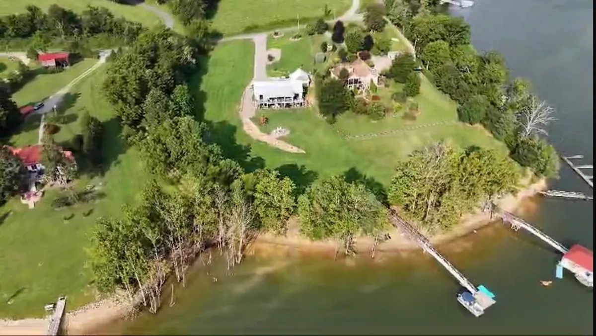 This exterior image showcases the estate’s scenic waterfront with wooden docks, a lush green lawn, and landscaped gardens. The calm water and open space are perfect for outdoor gatherings, toasts at sunset, and relaxing by the lake.